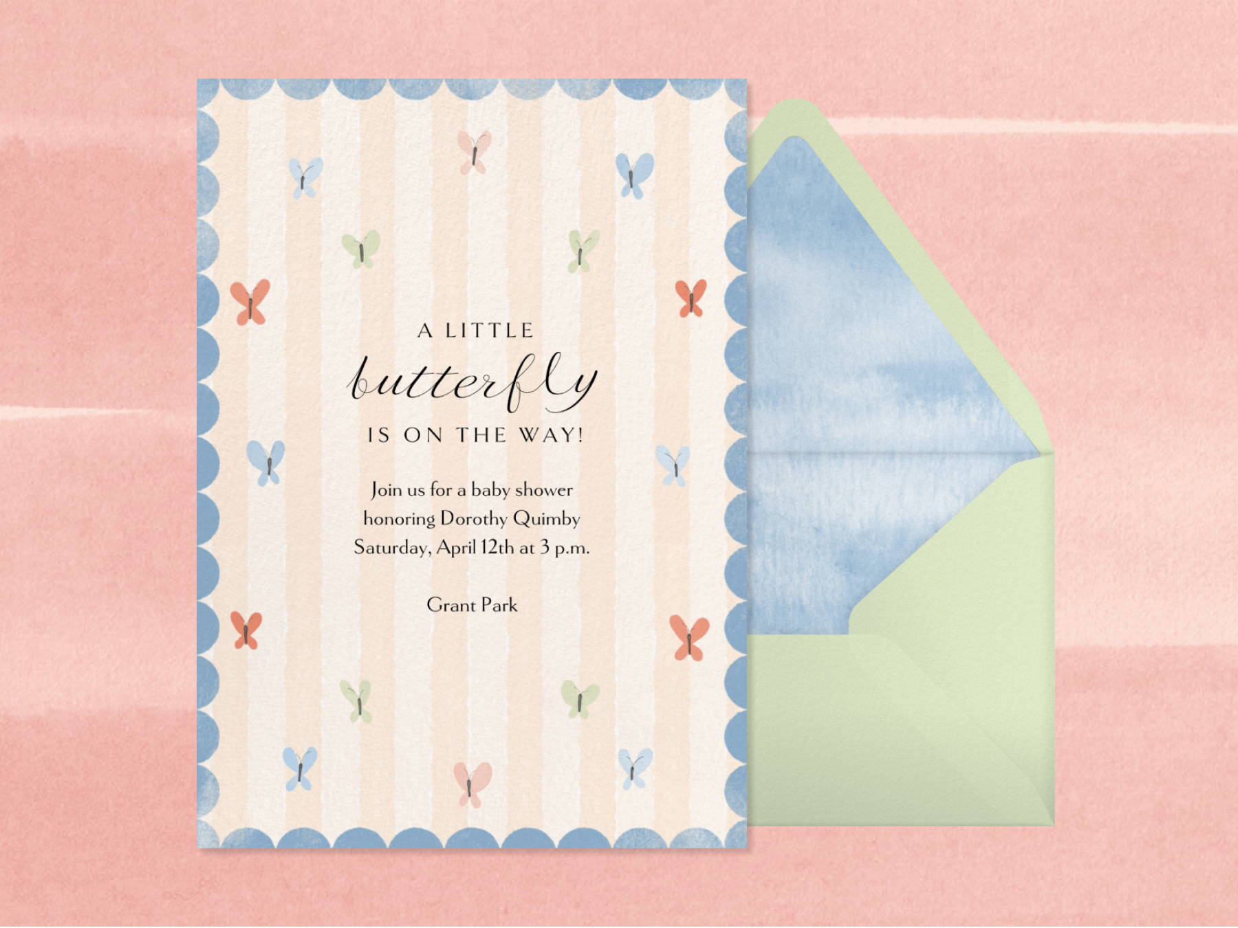 A baby shower invitation that reads “A little butterfly is on the way!” has light pink stripes, a blue scalloped border, and simplistic multicolored butterflies scattered about beside a green envelope with blue liner on a pink backdrop.