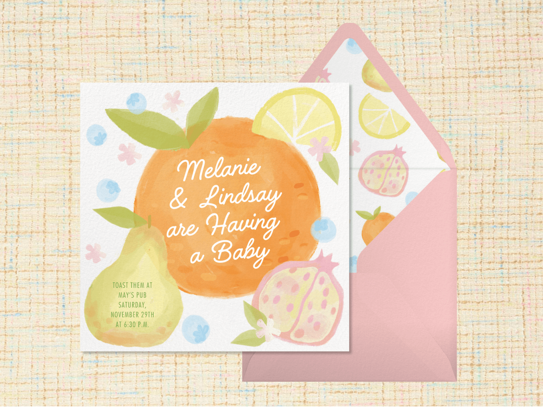 An invitation with overlapping watercolor fruit reads “Melanie & Lindsay are having a baby” with a pink envelope and matching liner.