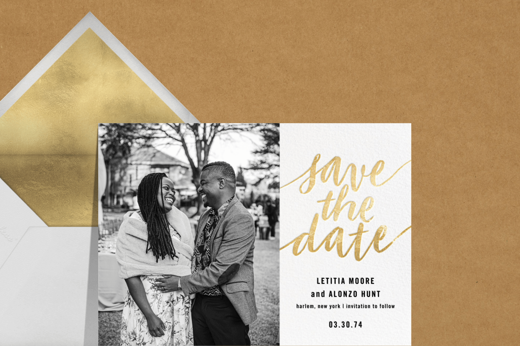 save the date with a black and white photo of a man and woman embracing and gold script lettering