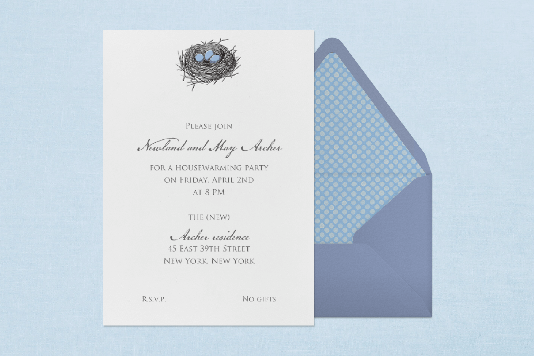 A housewarming party invitation on a light blue backdrop with a blue envelope and polka dot liner has a small illustration of a bird’s nest at the top with three blue eggs inside.