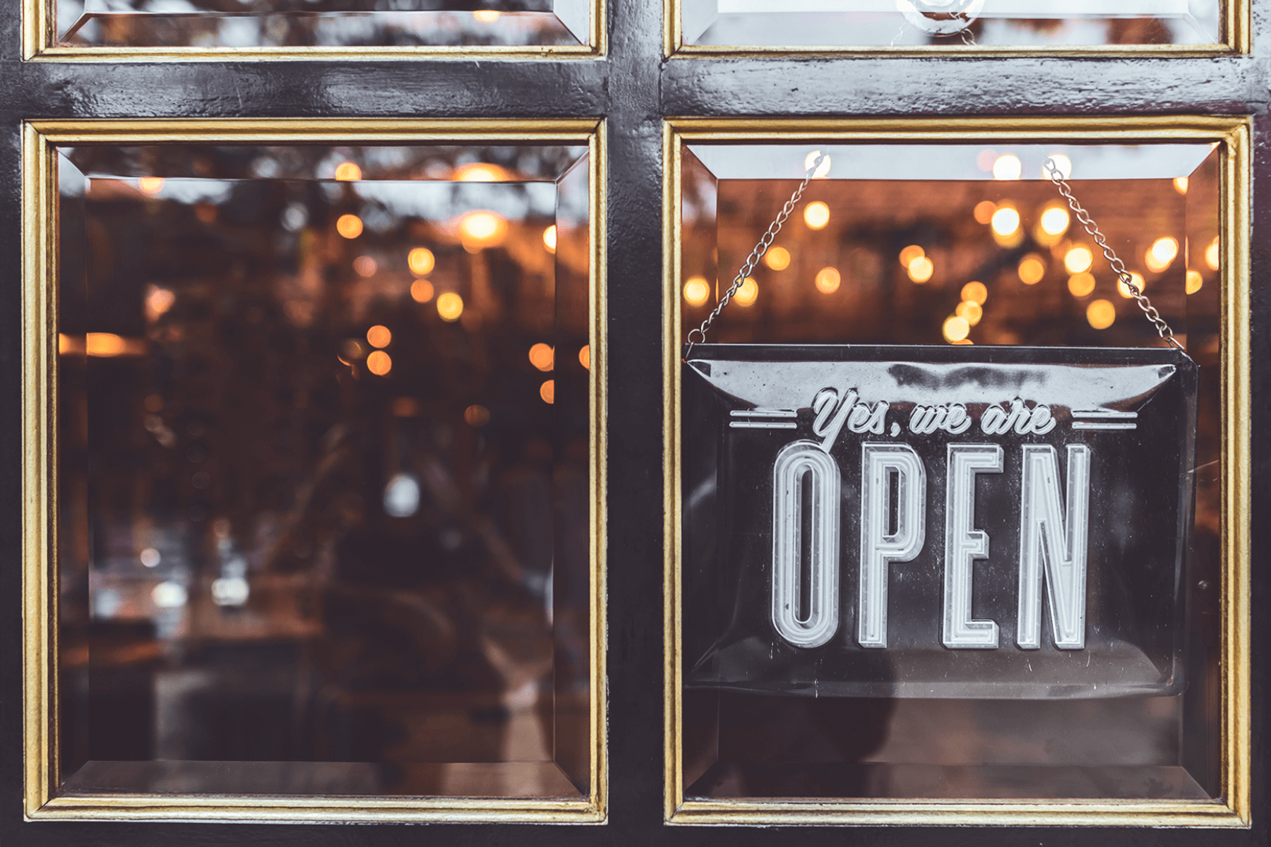 A window with a sign that reads “Yes, we’re open.”