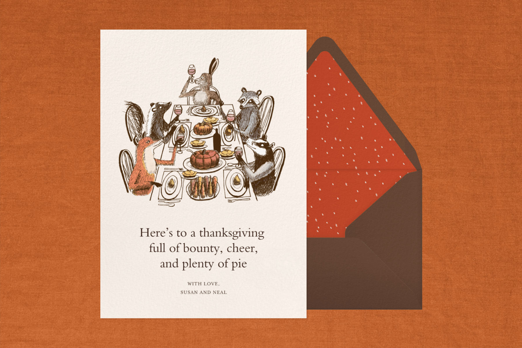 A Thanksgiving card with an illustration of woodland creatures sitting around a table toasting with glasses of wine before a meal.