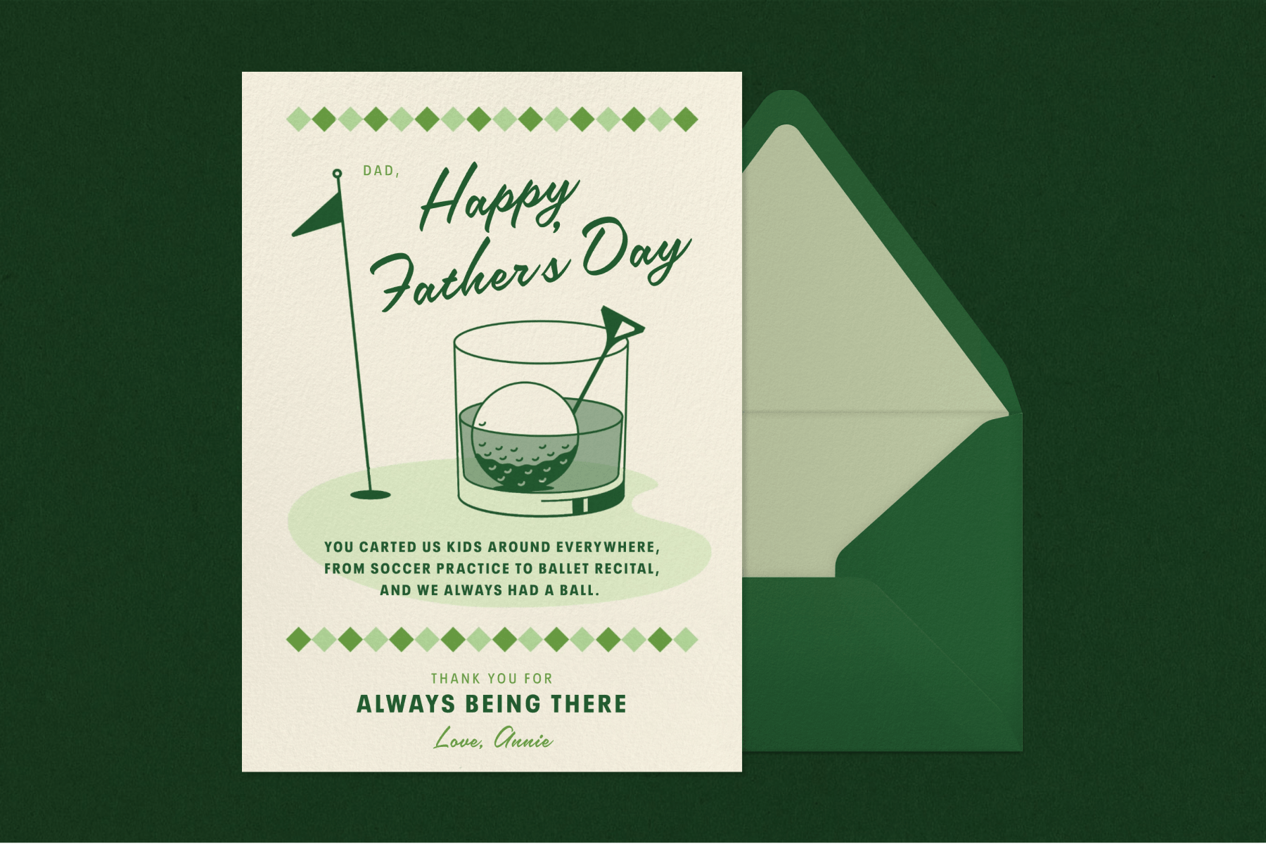 A green golf-themed Father’s Day card, adorned with an illustration of a cocktail with a golf ball garnish, sits to the left of a green envelope with a light green interior against a dark green backdrop.