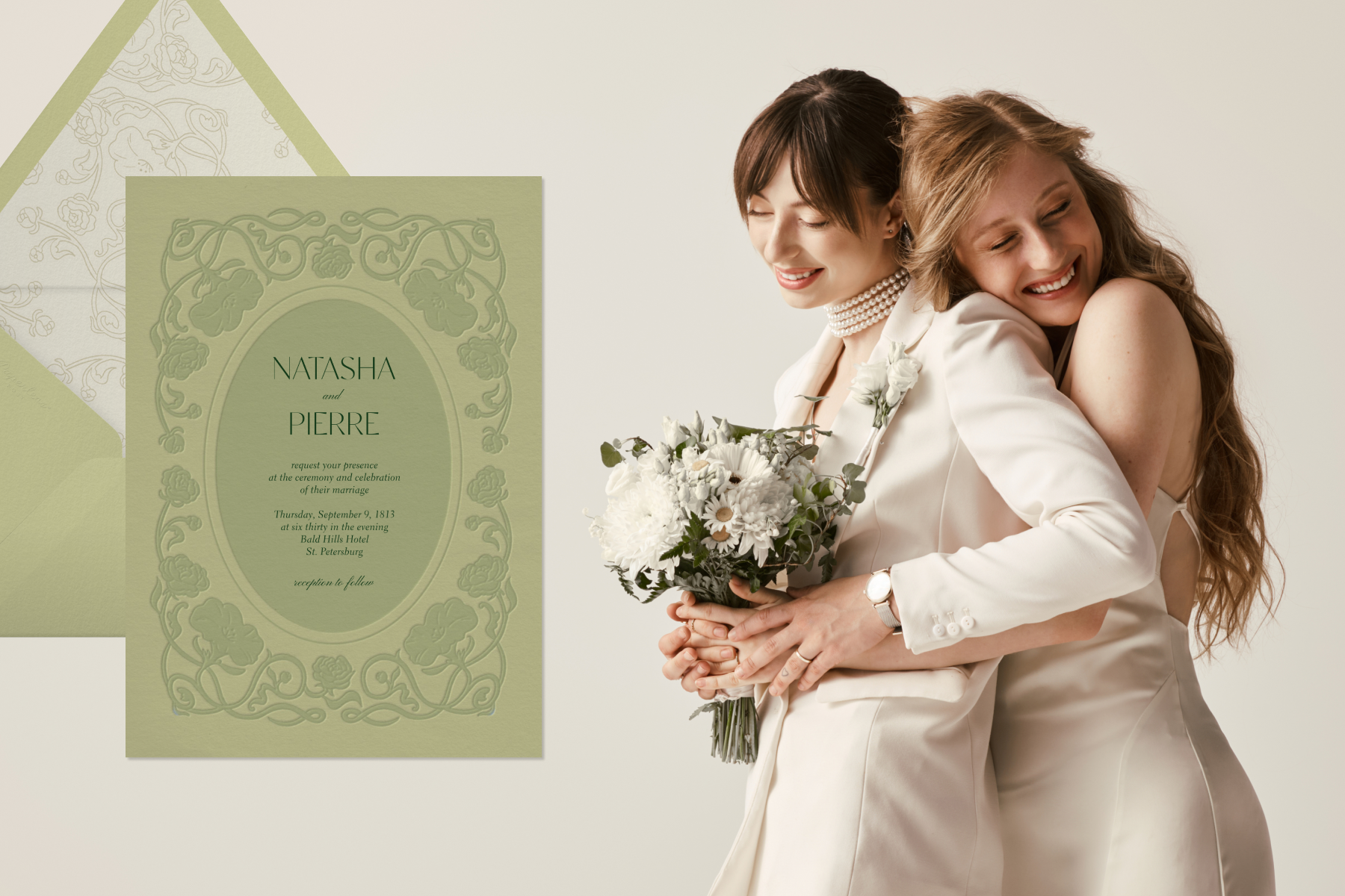 A green wedding invitation with an embossed floral border next to two brides embracing while one holds white flowers. 