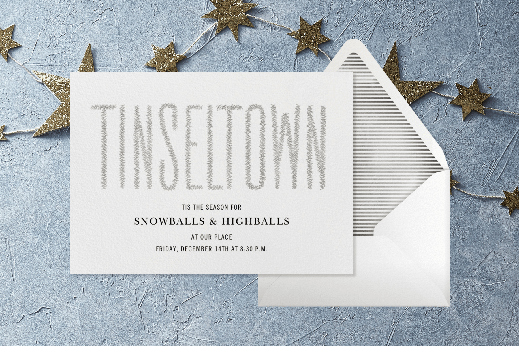 A white holiday invitation that reads “Tinseltown.” A glitter star garland lines the background.