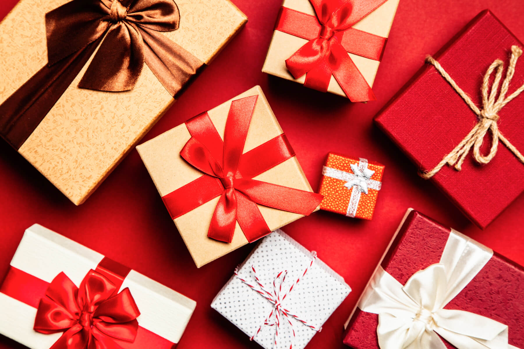 Overhead photograph of gifts on red background.