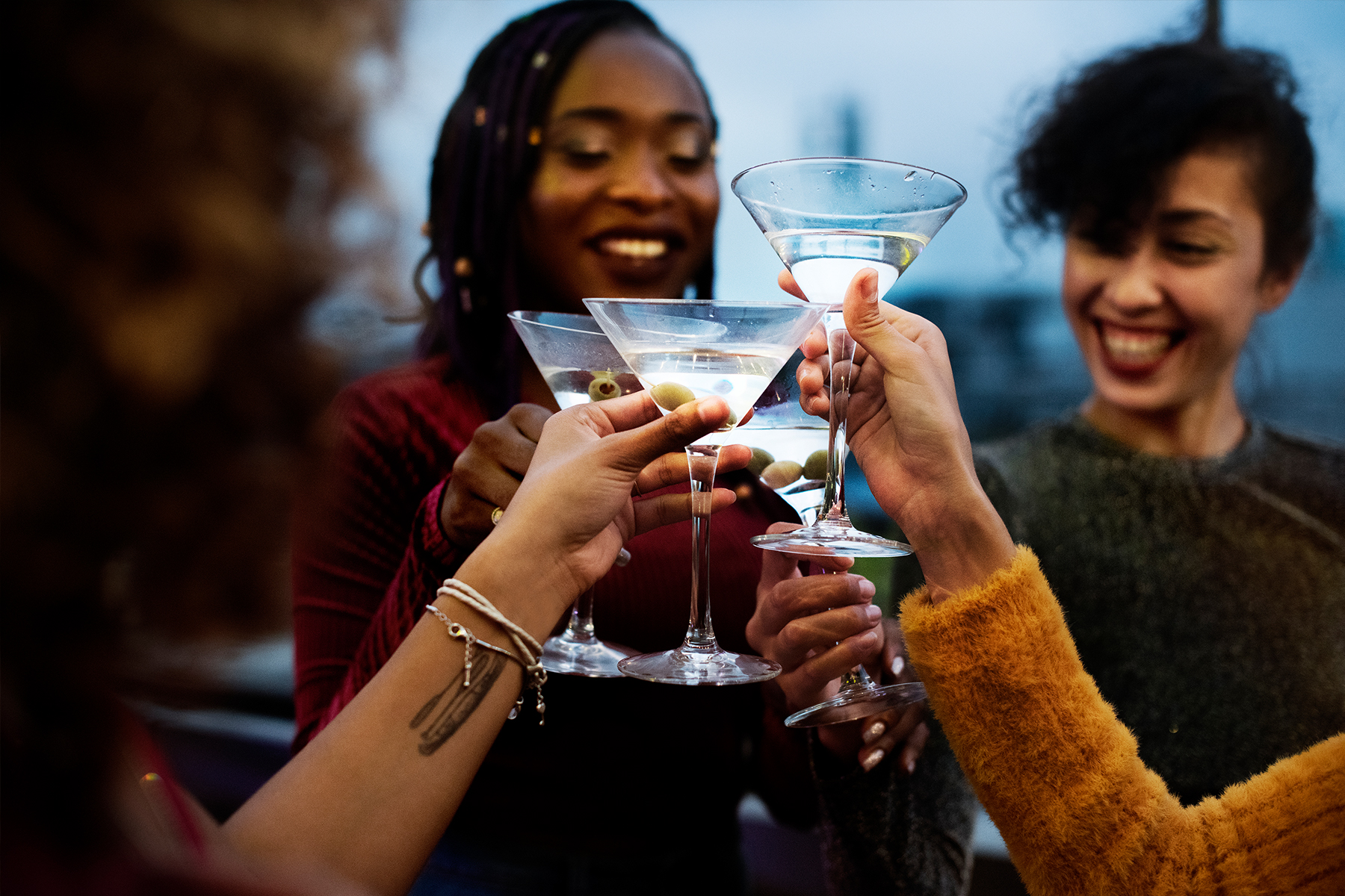 Photo of friends cheersing their cocktails at an outdoor party.