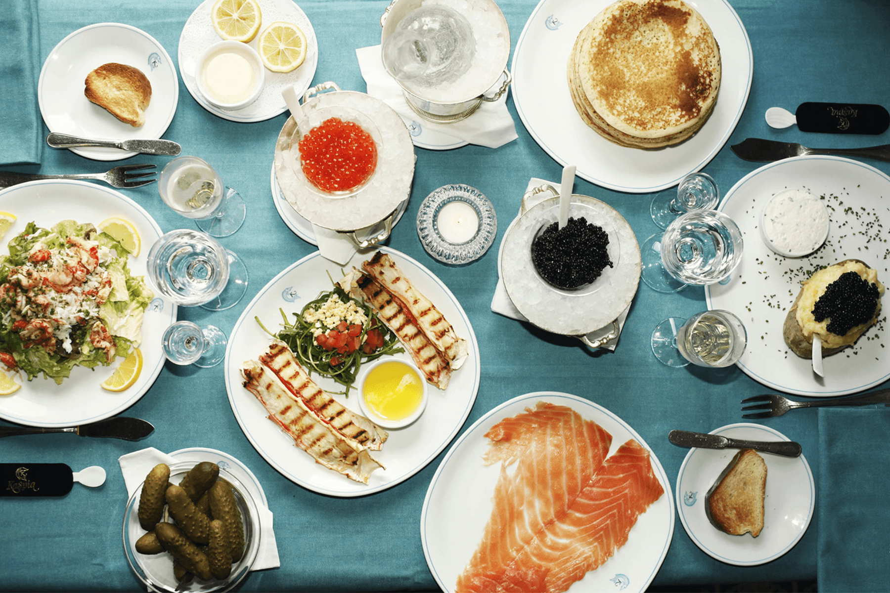 An overhead shot of party food, including meats, caviar, and champagne.