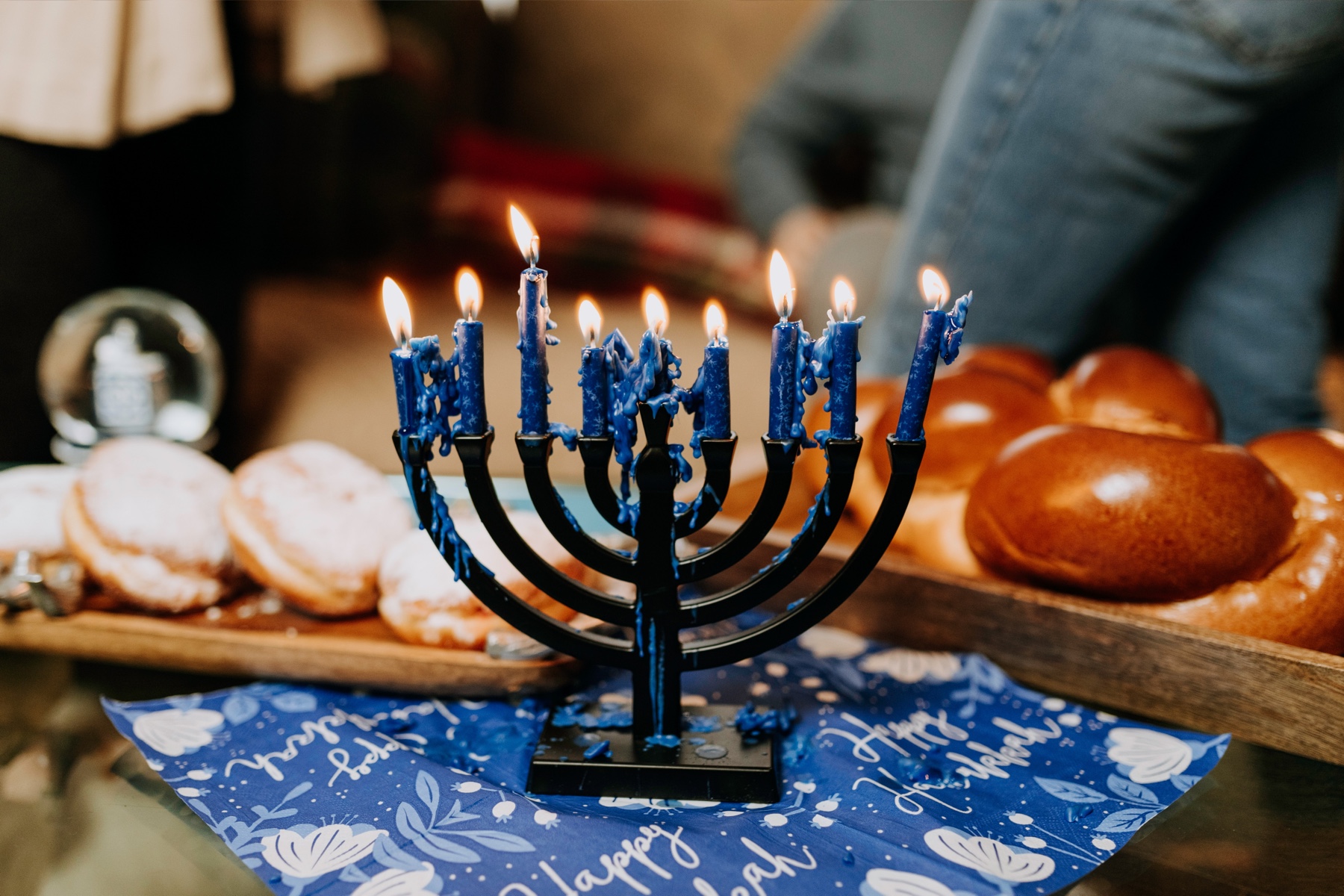 A black Chanukiah with lit blue candles.