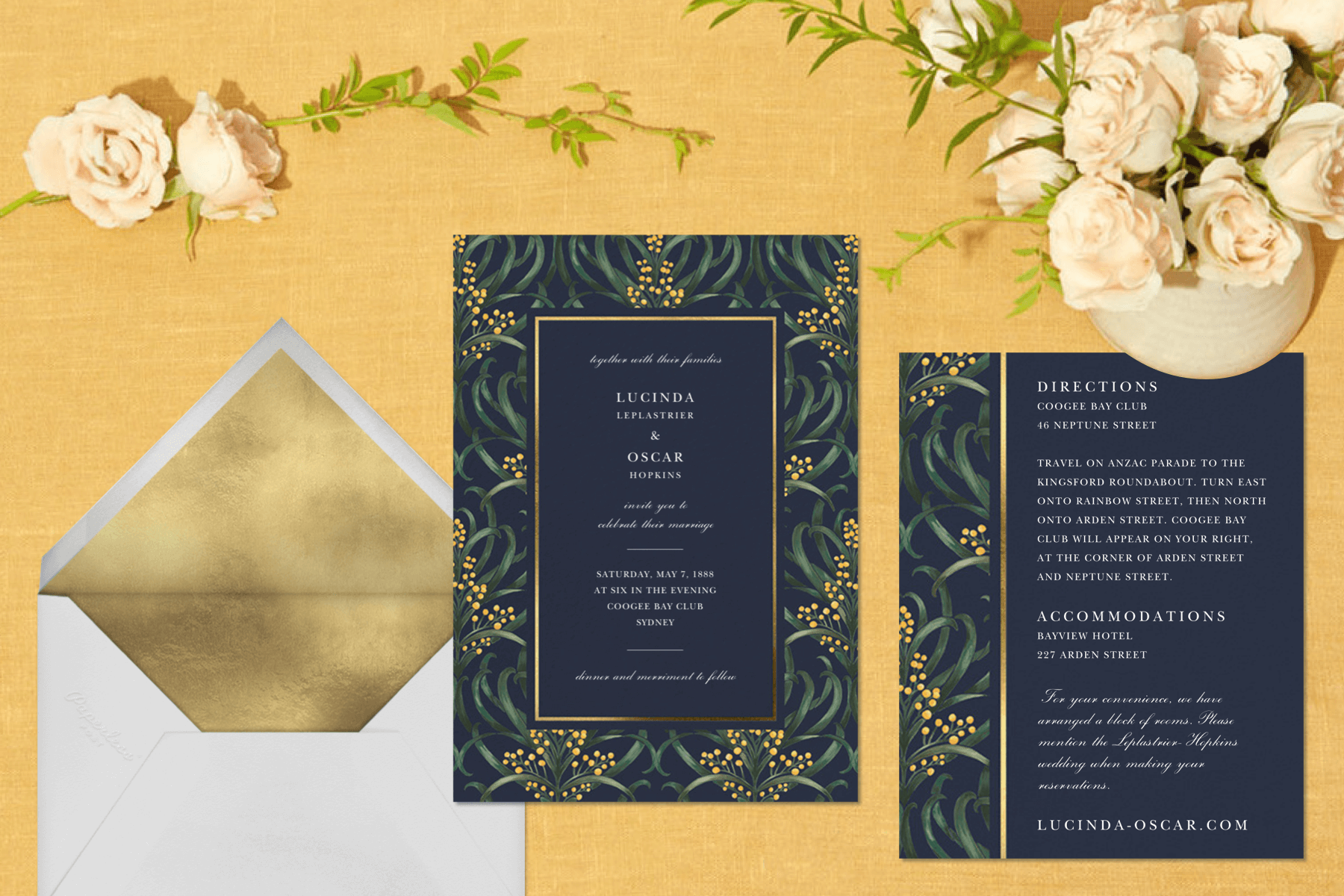 Navy wedding invitation and insert with leafy border and white envelope with gold liner. 