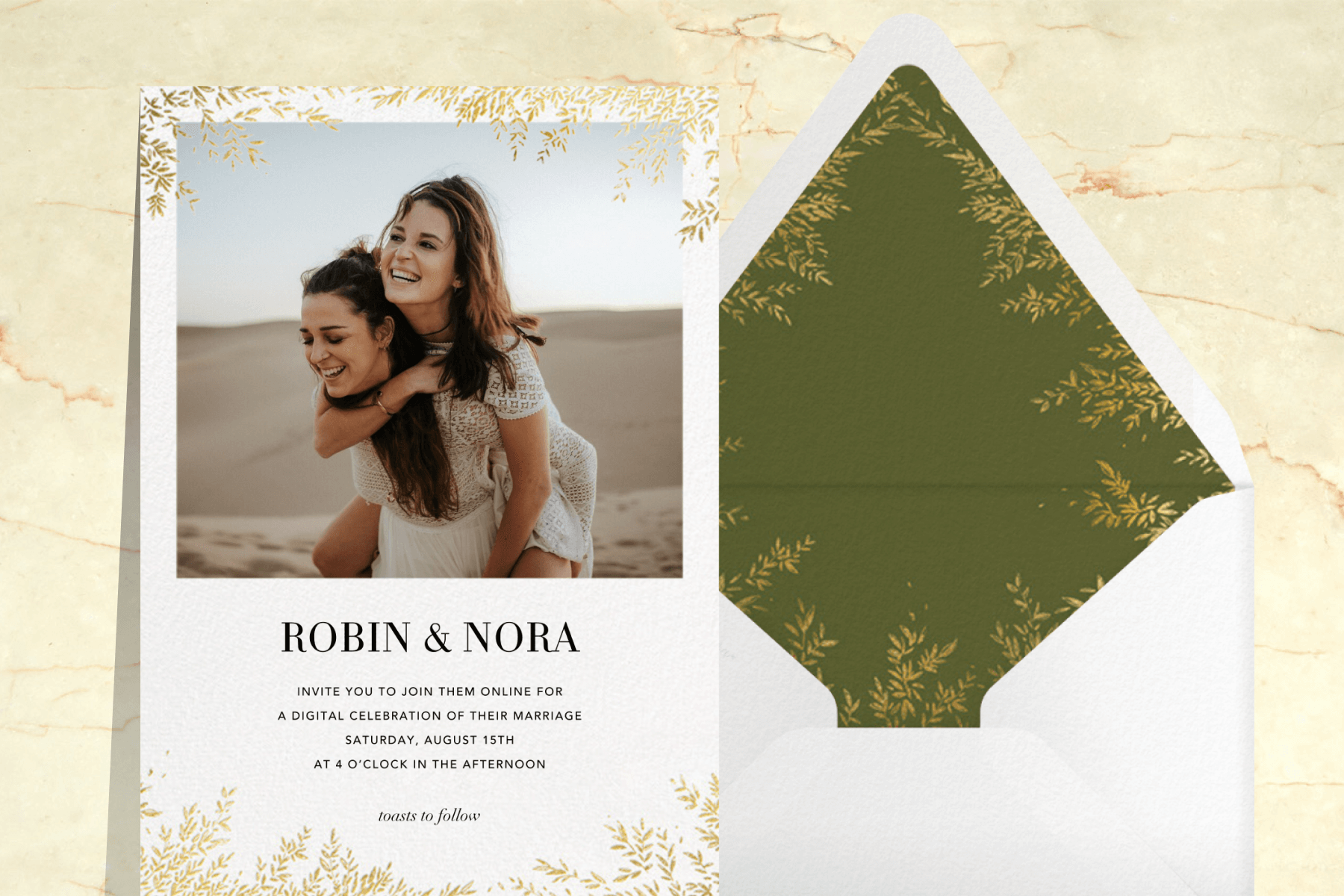 A white photo card with gold leaves along the edges, paired with a matching envelope liner in green. The background is cream marble.