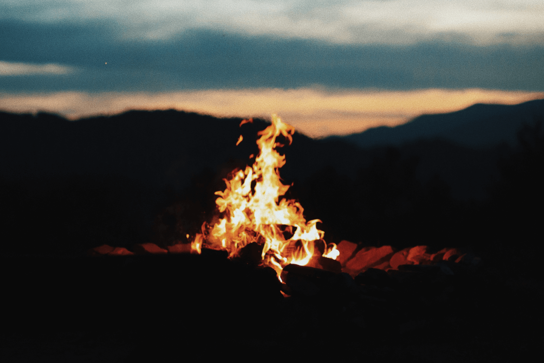 A dark photo of an outdoor bonfire.