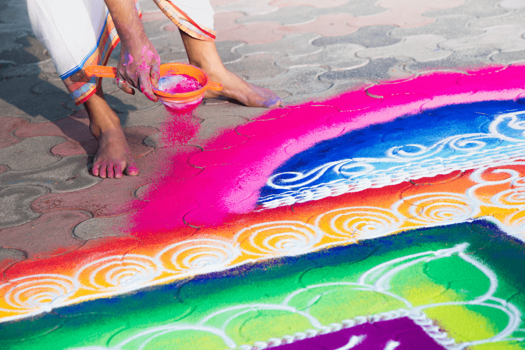 Close up of a person decorating their home with Rangoli drawings.