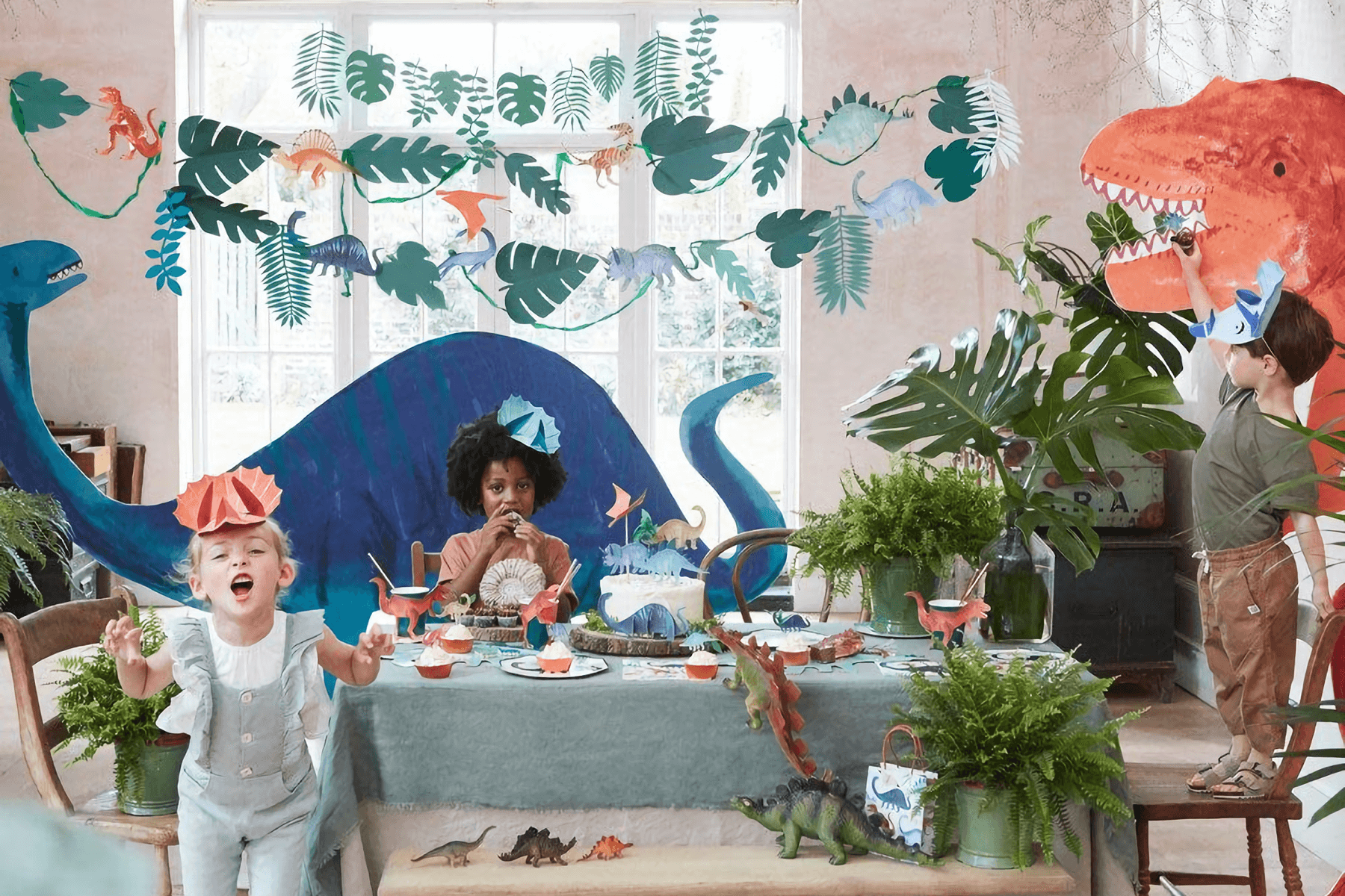 Three children play at a dinosaur-themed party.