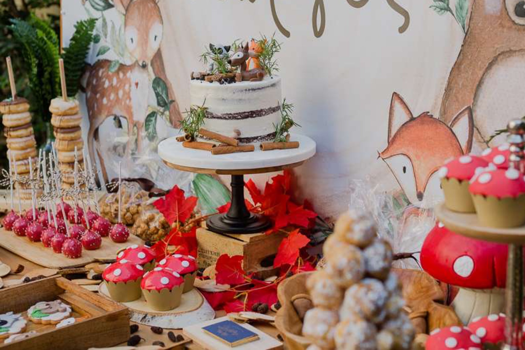  Una mesa de postres en una fiesta infantil con temática de animales del bosque. 