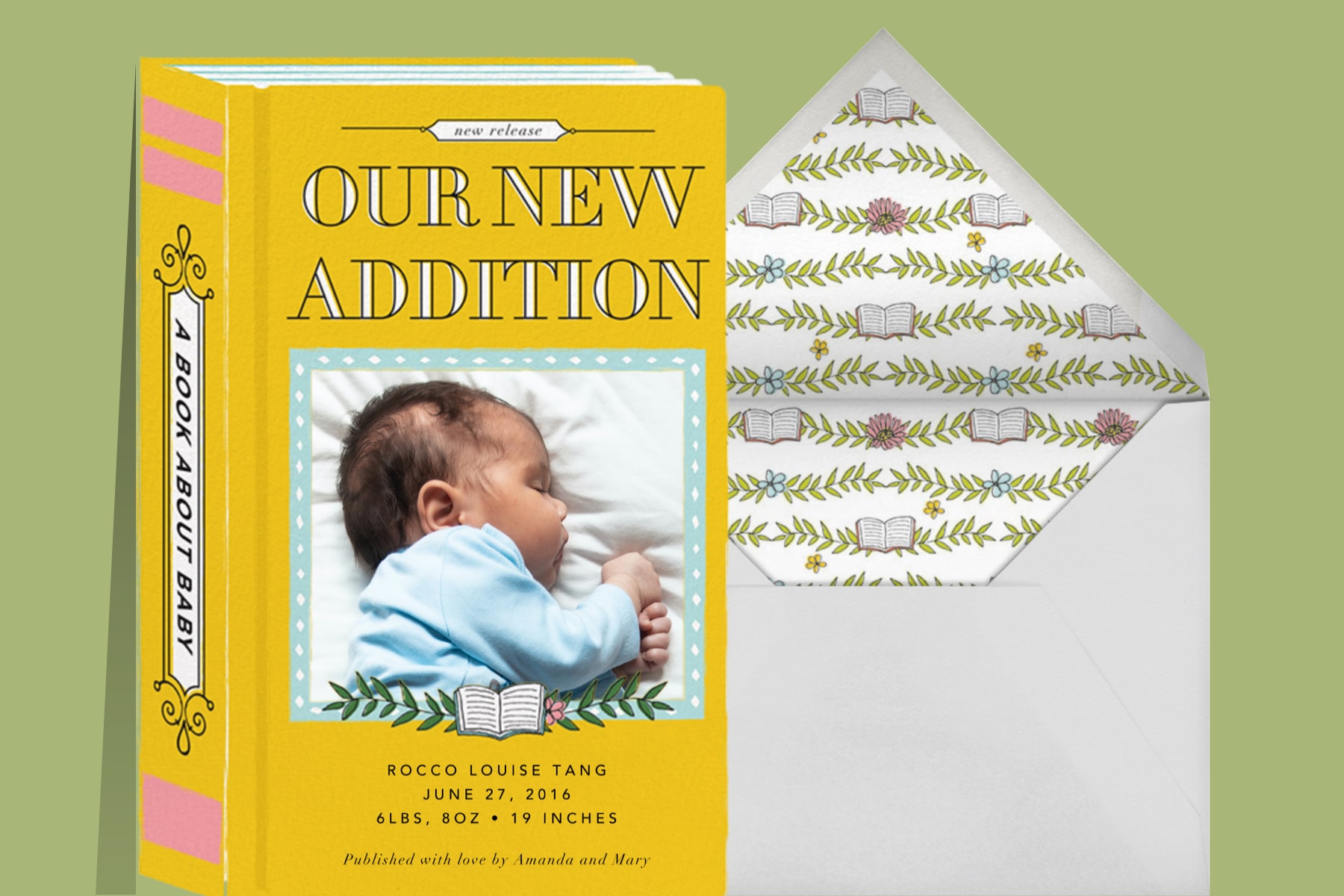 “Chapter One (Photo)” invitation by Cheree Berry Paper & Design for Paperless Post. The yellow card is shaped like a book and features a customizable photo opening. The text reads “Our New Addition.” The card is featured on a green background.