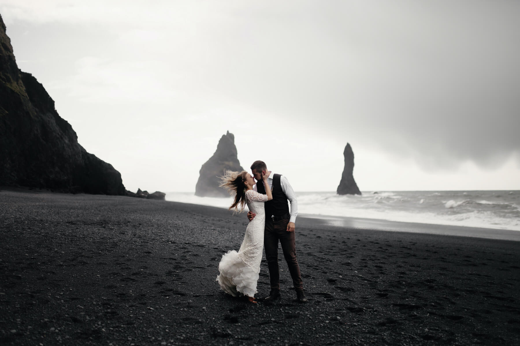Photo of a bride and groom embracing on the beach.