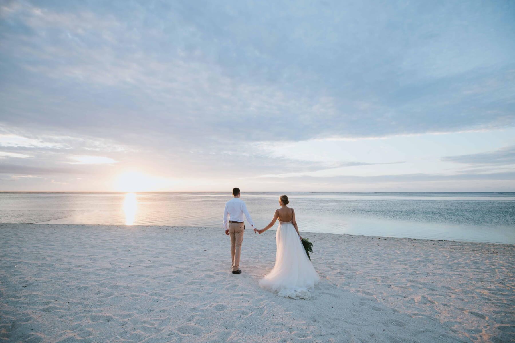 Bride and groom on the beach at sunset