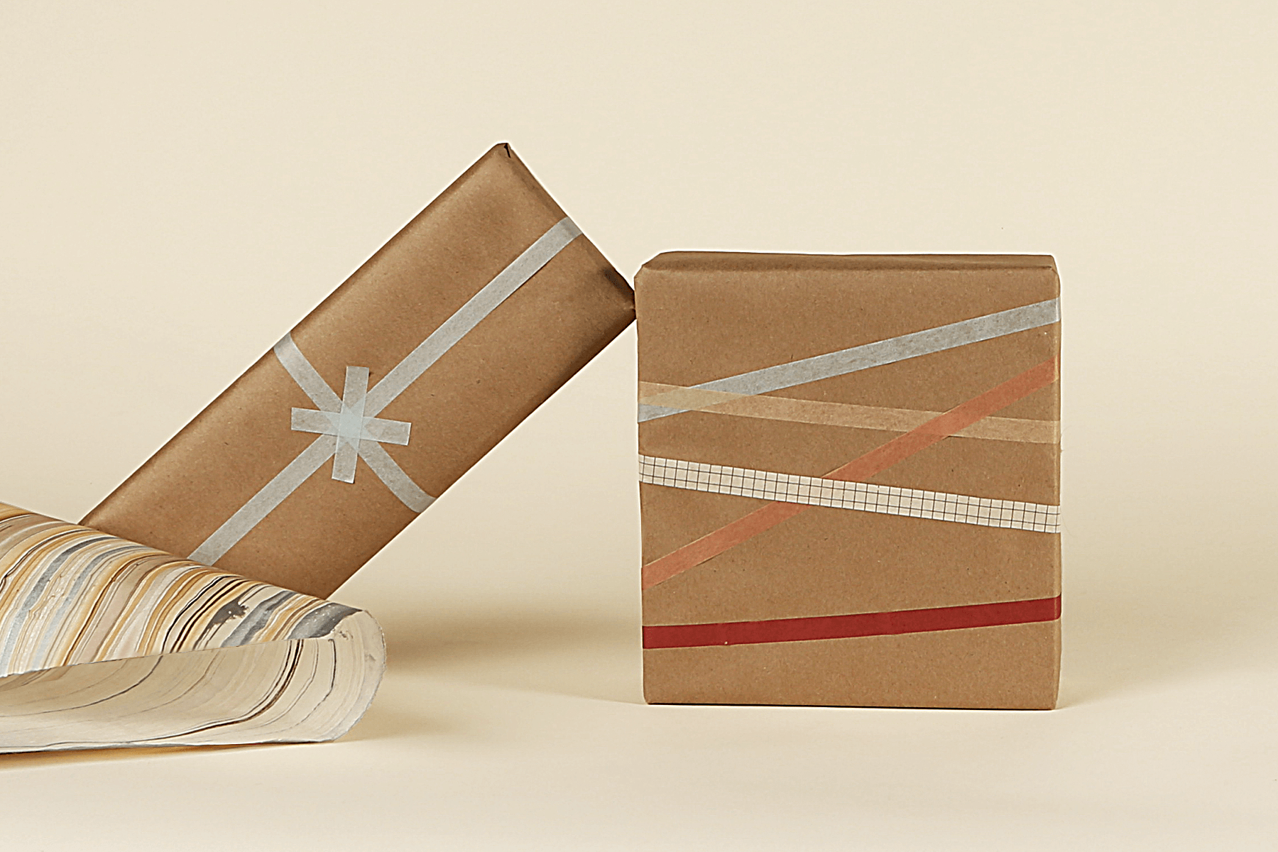 Stack of eco-friendly wrapped gifts on a beige background.