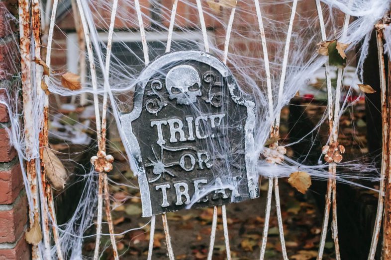 Photo of Halloween decor—a gravestone and cobwebs.