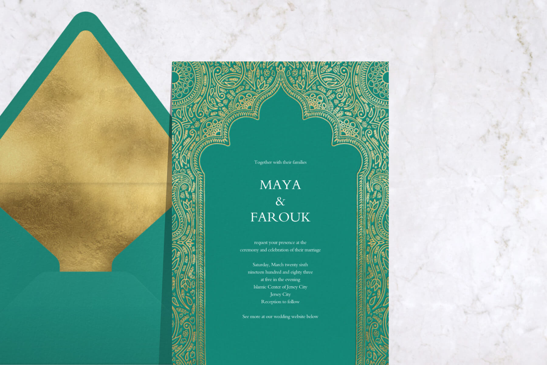 A turquoise Indian wedding invitation with an ornate gold border paired with a matching envelope.