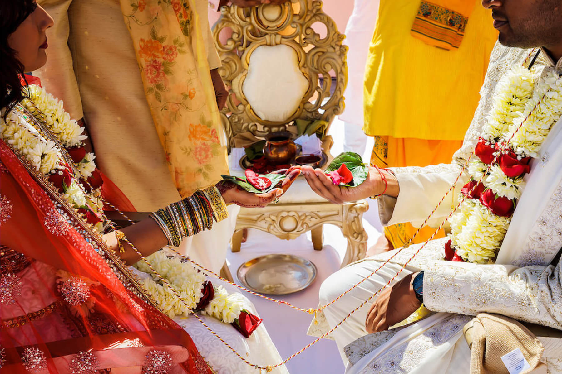 Photo of a bride and groom holding flower petals at their Indian wedding 