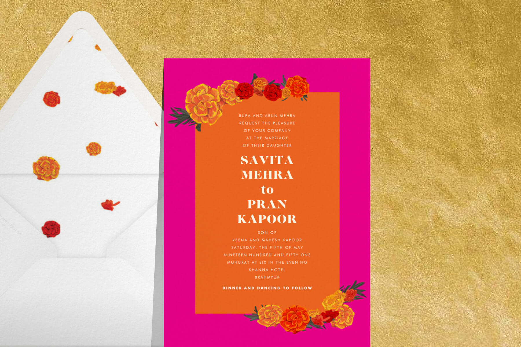 A pink and orange Indian wedding invitation featuring marigold illustrations, paired with a white envelope with a matching liner.