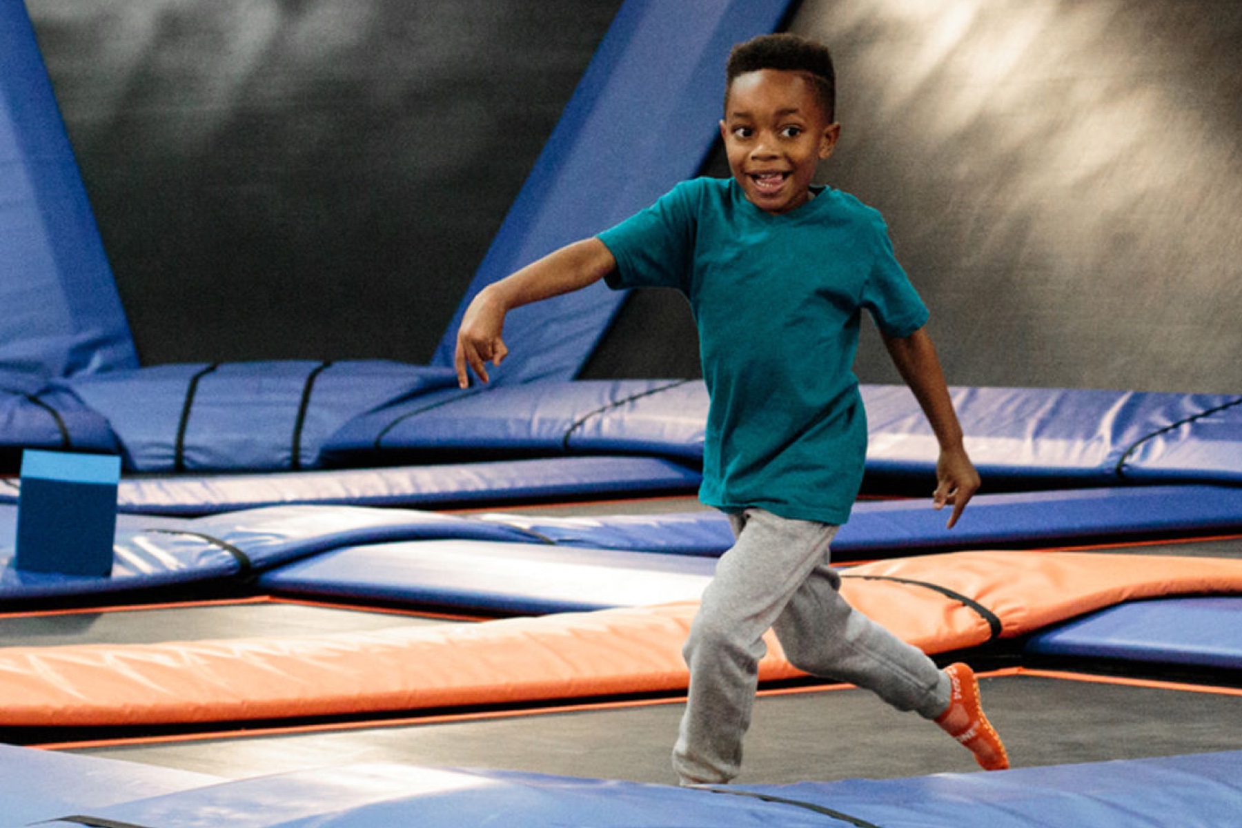 A young boy on a large trampoline.