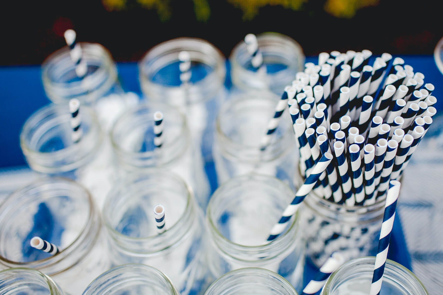 Mason jars on a table with blue and white striped straws