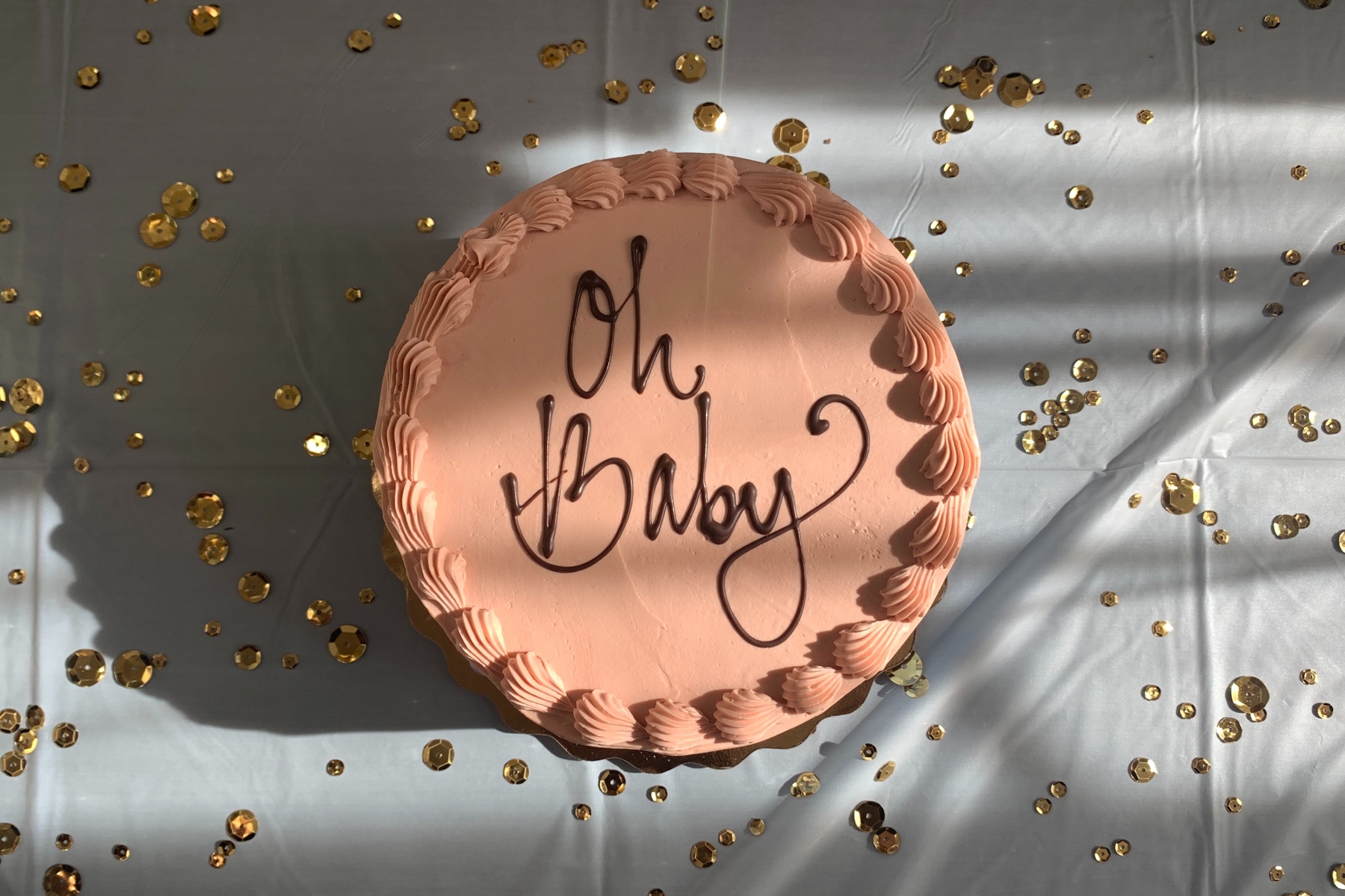 Photo of a cake with the phrase "Oh Baby" in script