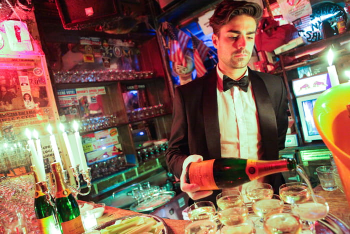 bartender in tuxedo pouring drinks
